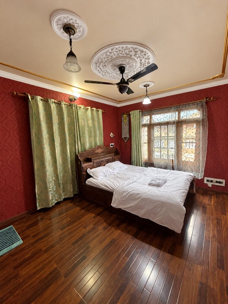 Doctors Lodge Srinagar red bedroom — enhanced original photo